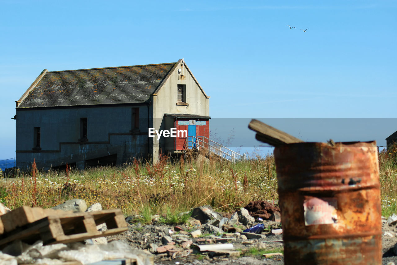 ABANDONED HOUSE AGAINST BLUE SKY