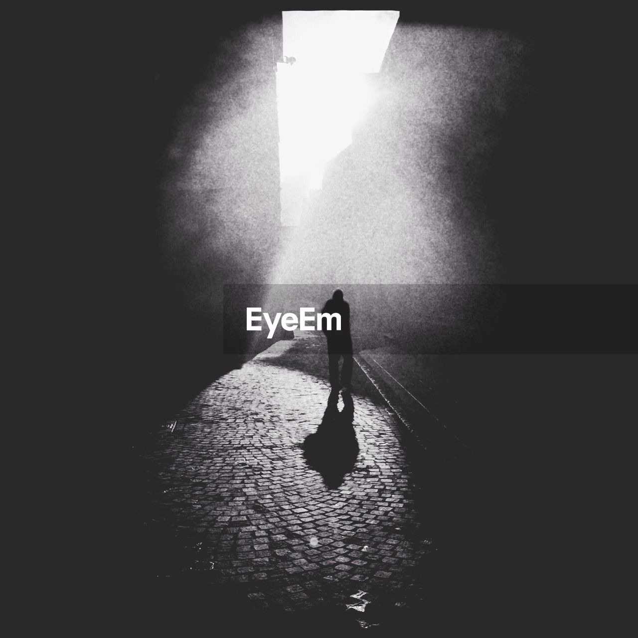 Silhouette of man in narrow alley