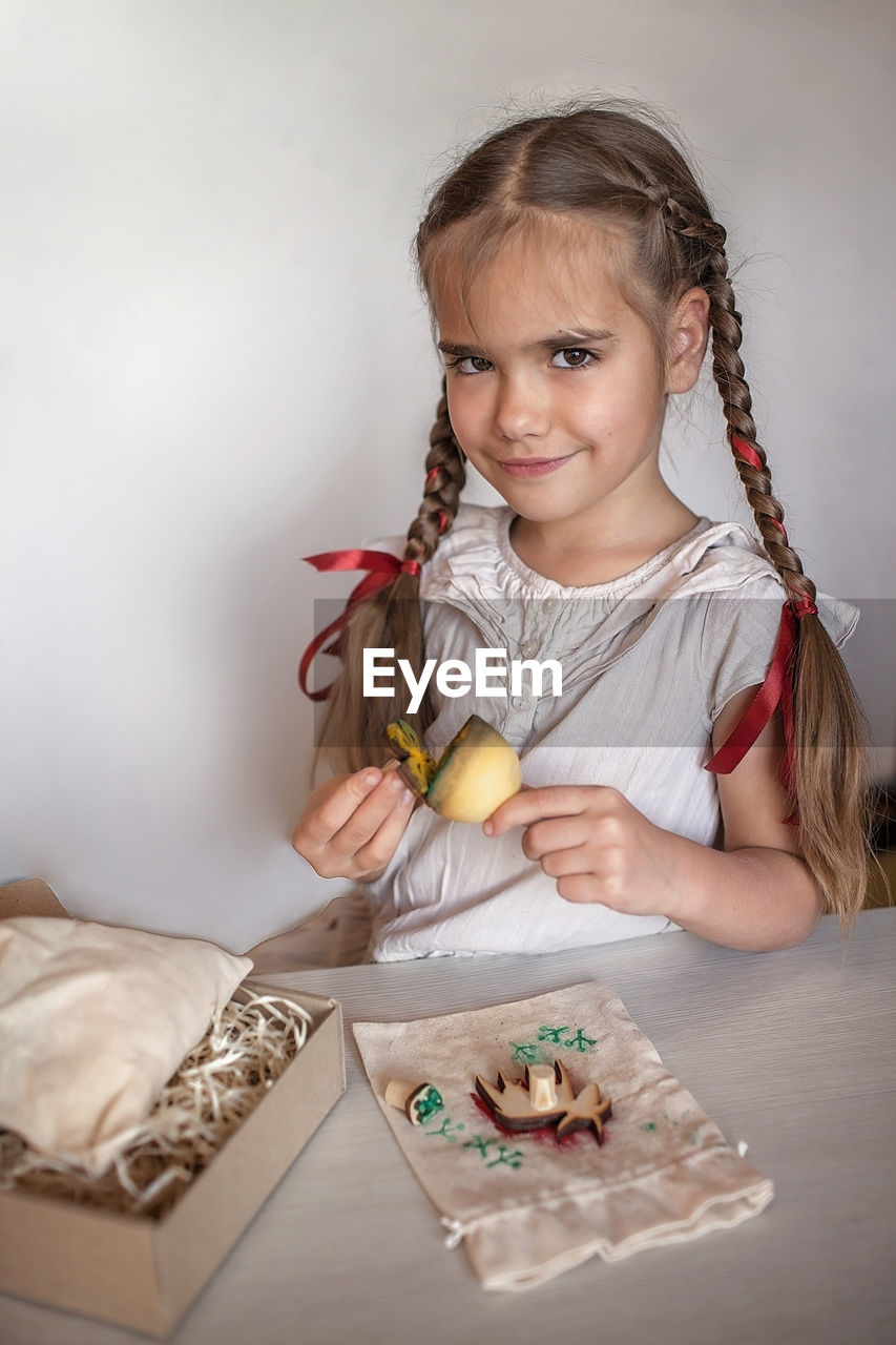 Girl doing craft wrapping for festive gifts with stamp printing technique