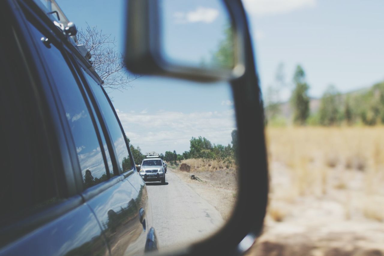 CARS ON ROAD SEEN THROUGH SIDE-VIEW MIRROR