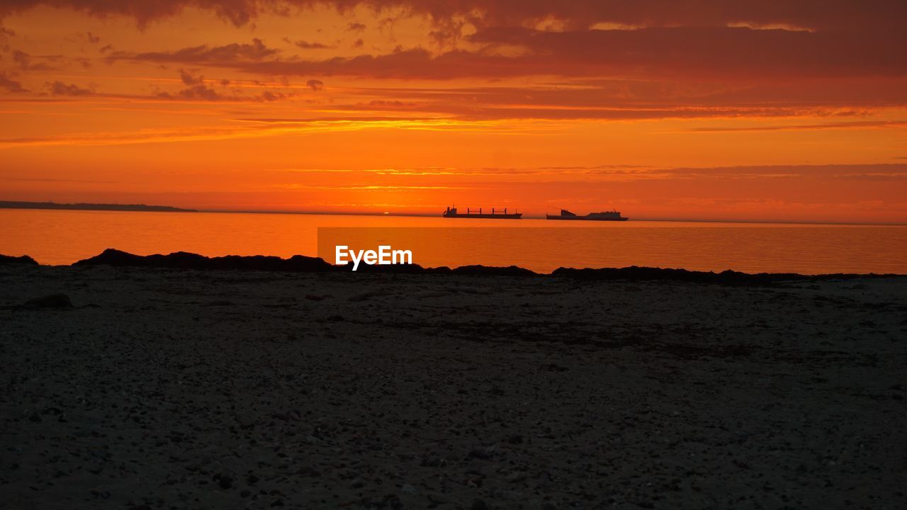 Scenic view of sea against orange sky