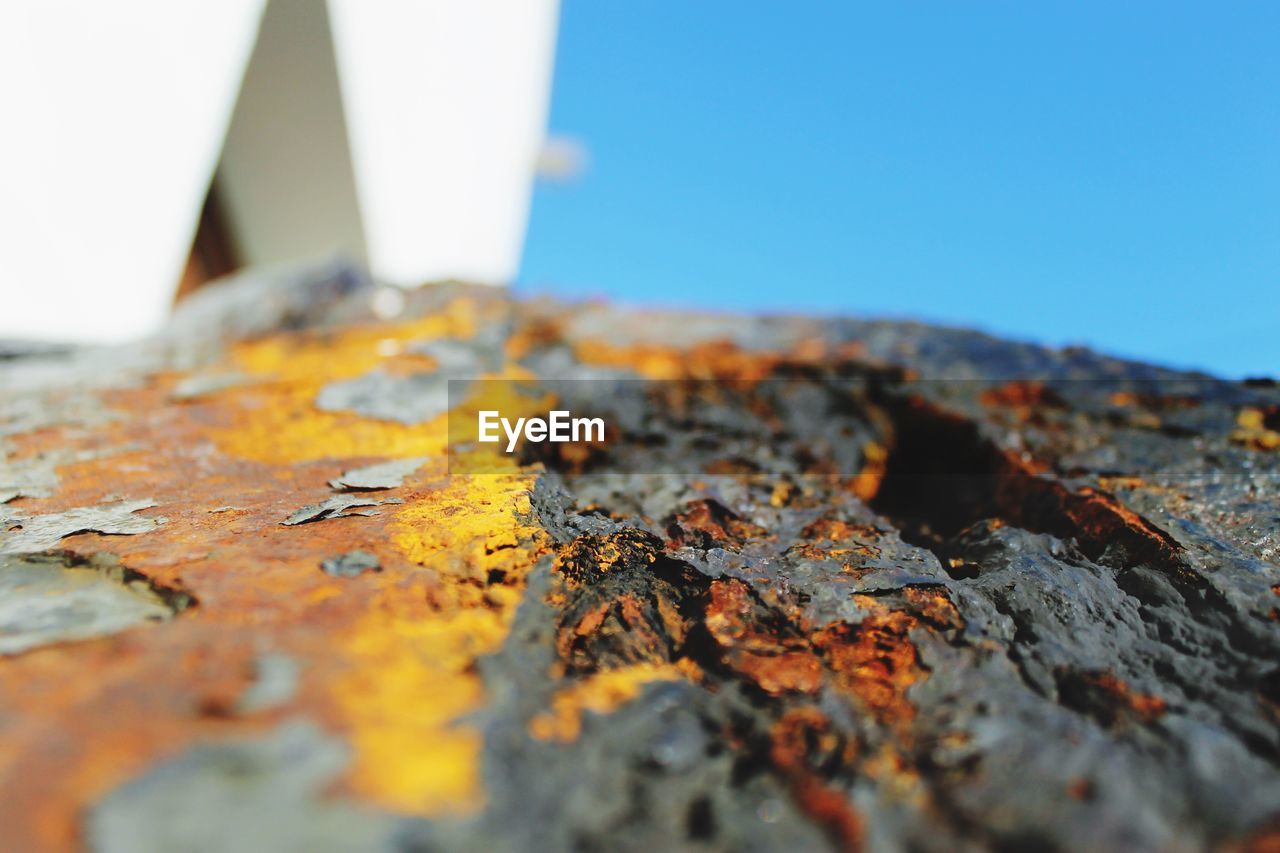 Close-up of cropped old anchor against clear blue sky