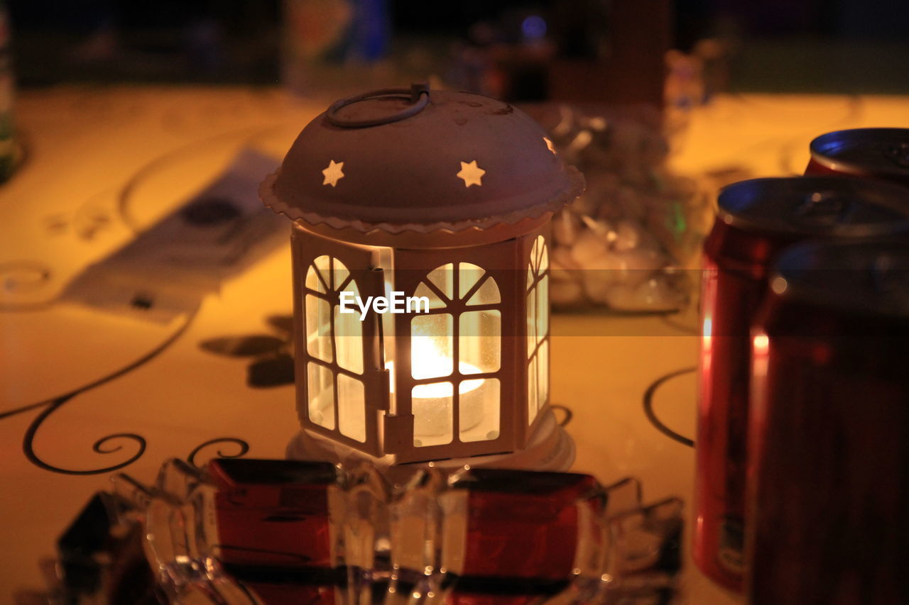 CLOSE-UP OF LIT LANTERN ON THE WALL