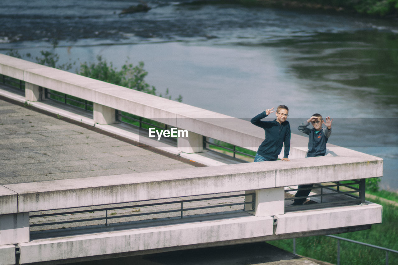 Mid distance view of boys gesturing while standing on building terrace