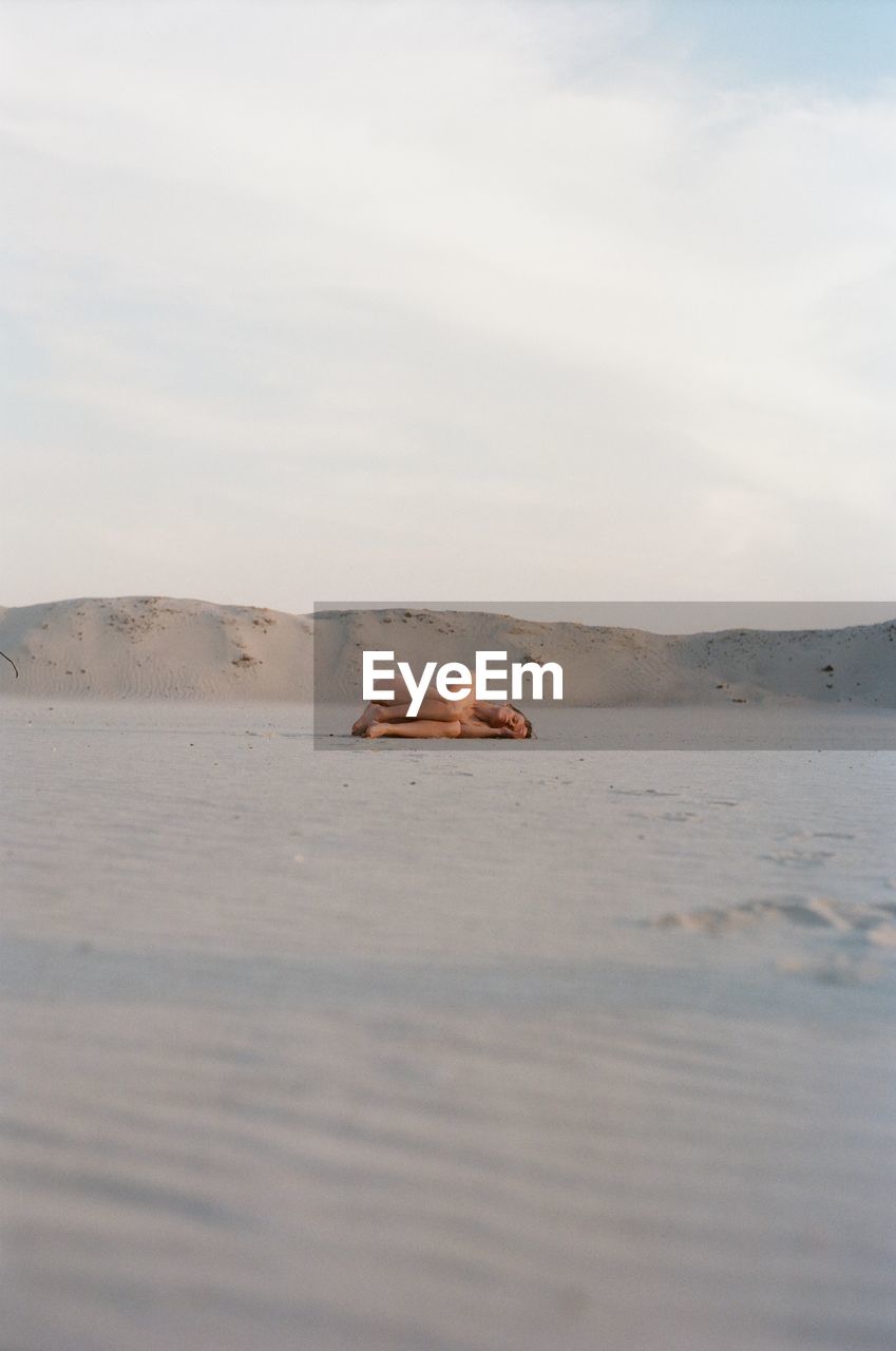 MAN ON SHORE AGAINST SKY