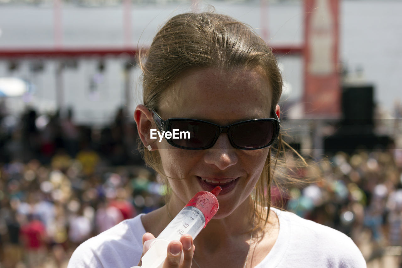 Close-up of woman drinking jello shot from syringe