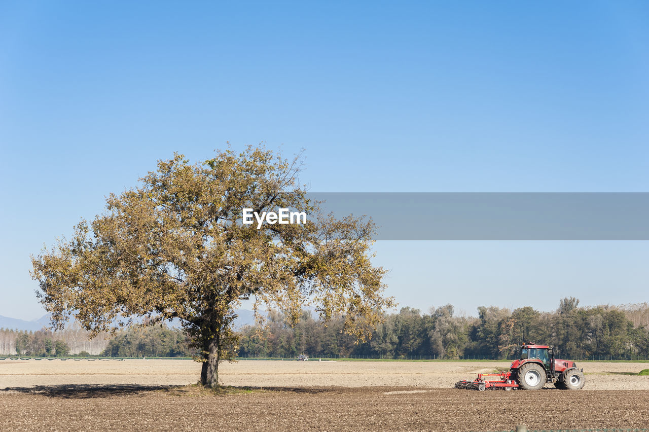 Tractor on field against clear sky