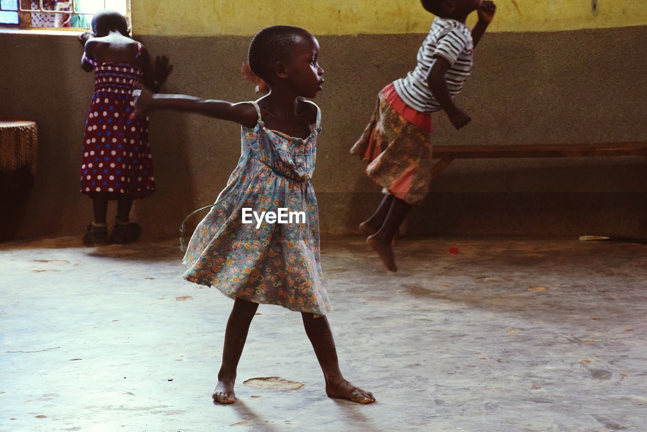 FULL LENGTH OF GIRL DANCING ON FLOOR IN SHOPPING MALL