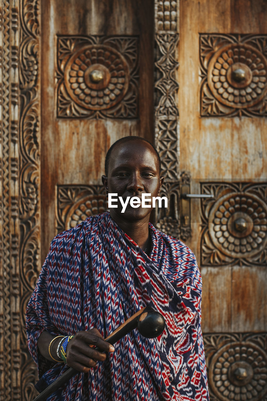 Masai men standing in front of a traditional door in old town