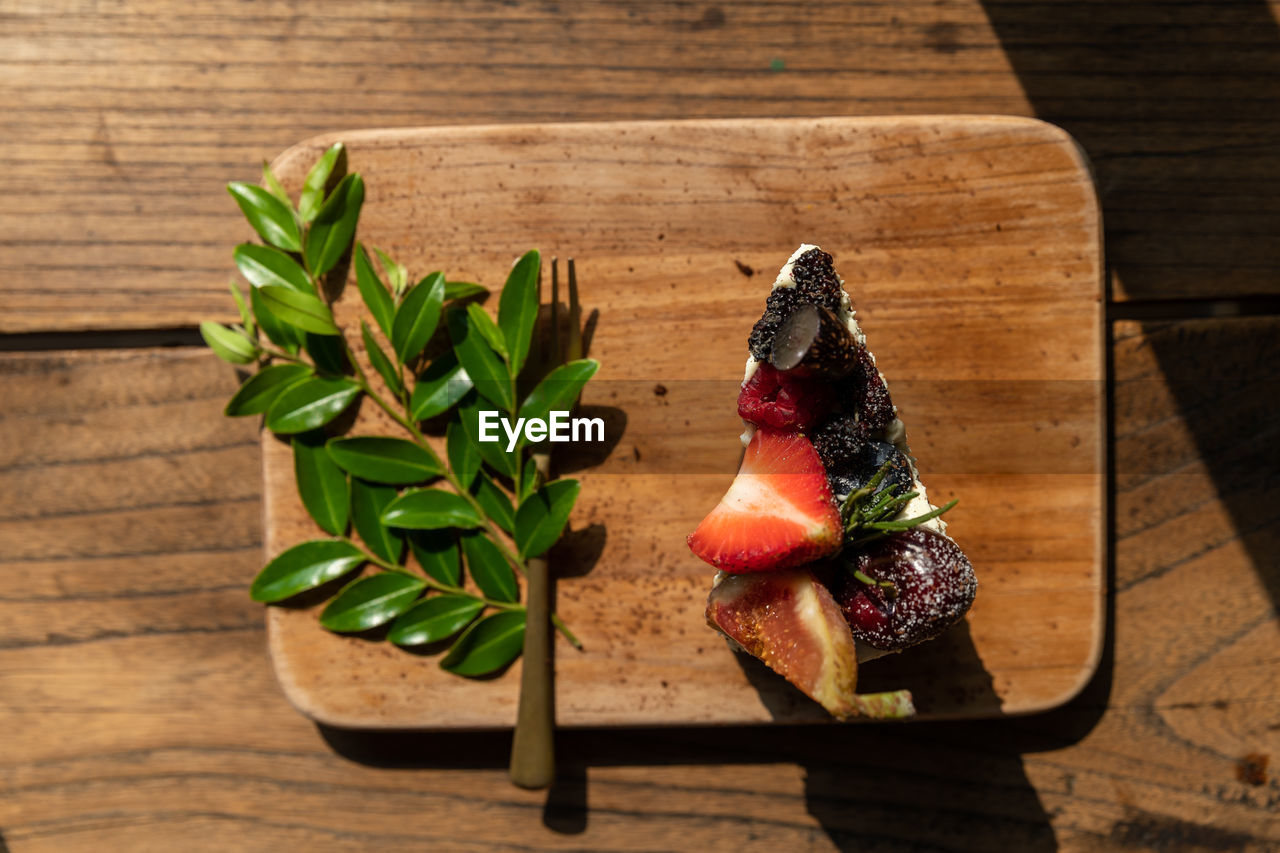 wood, food and drink, food, freshness, table, leaf, healthy eating, plant part, produce, plant, indoors, no people, wellbeing, nature, herb, high angle view, still life, fruit, flower, red, berry, close-up, strawberry, green, vegetable