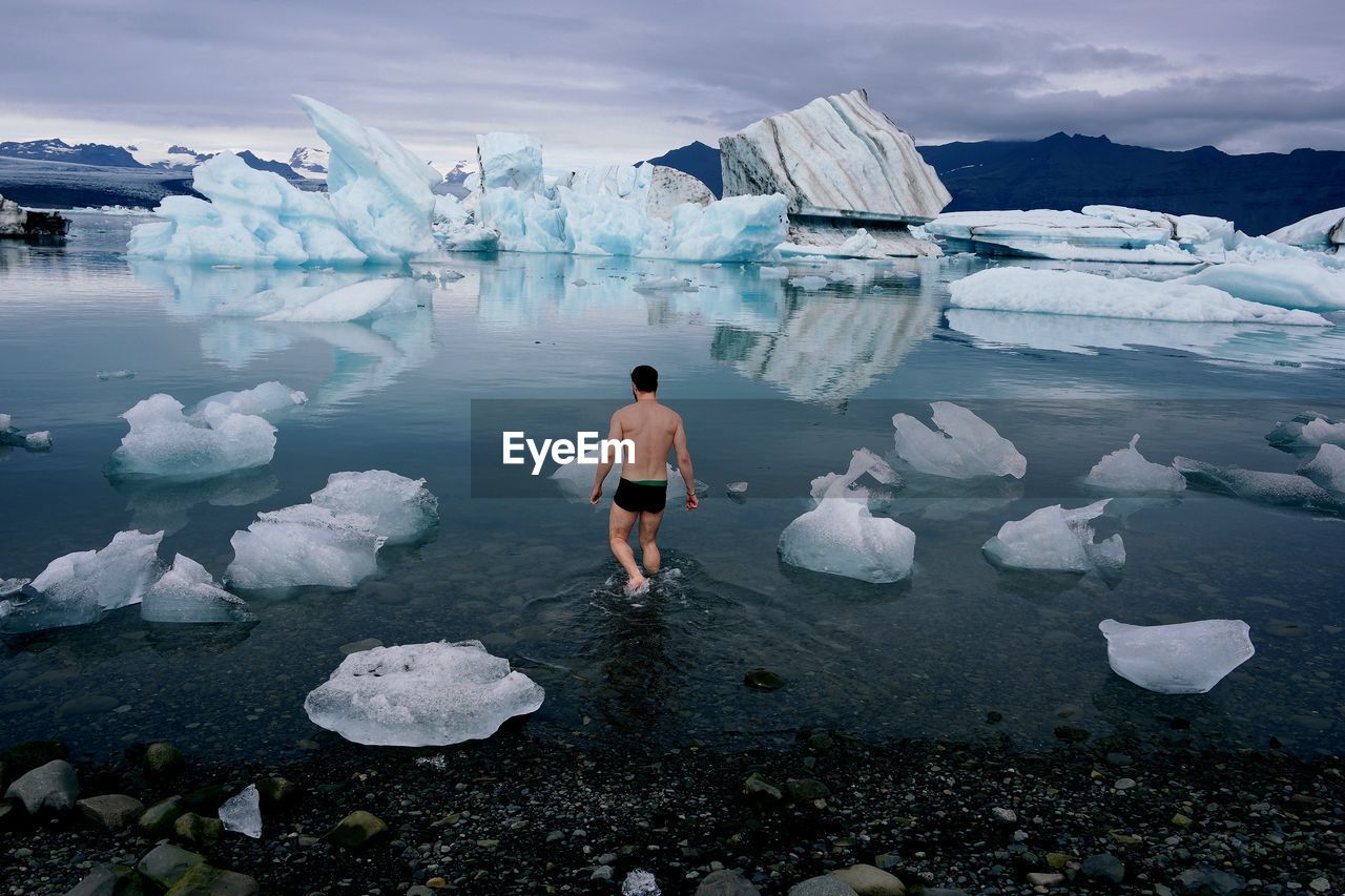 Rear view of man in frozen water