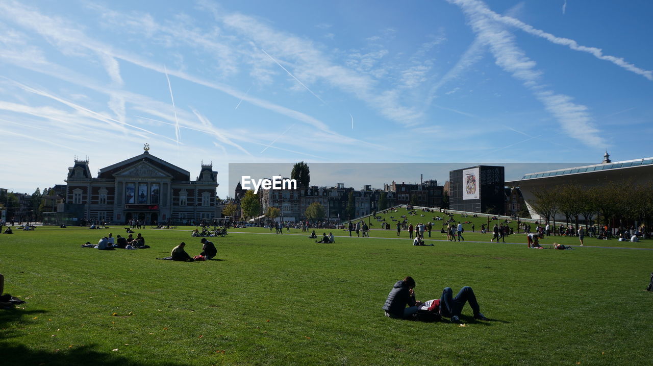 PEOPLE ON FIELD AGAINST SKY