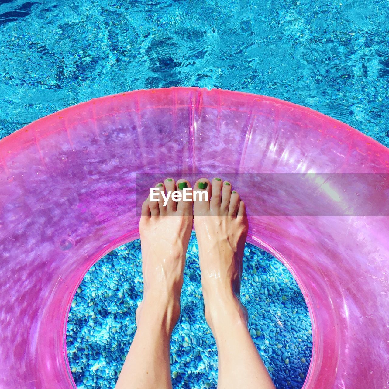 Low section of woman relaxing in swimming pool