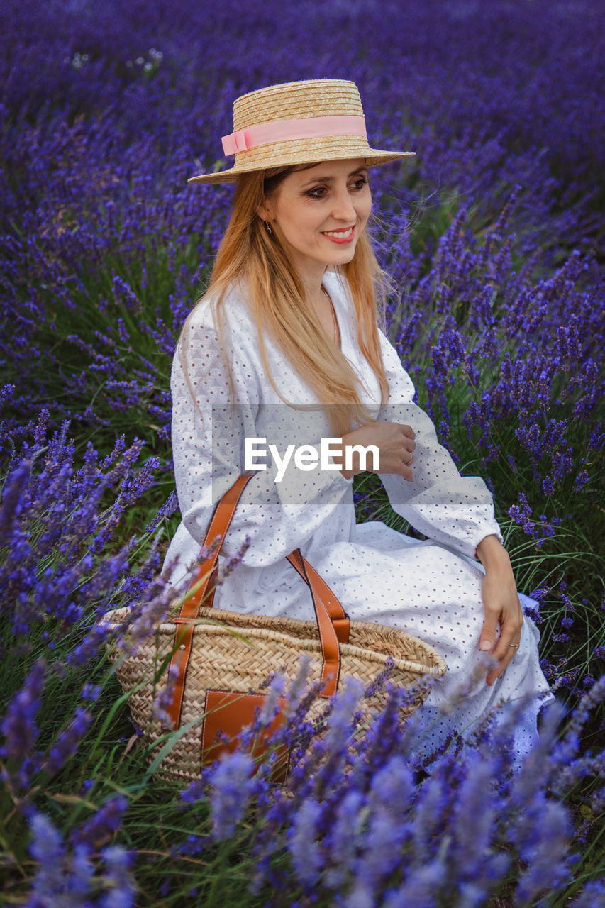 portrait of smiling young woman standing amidst plants