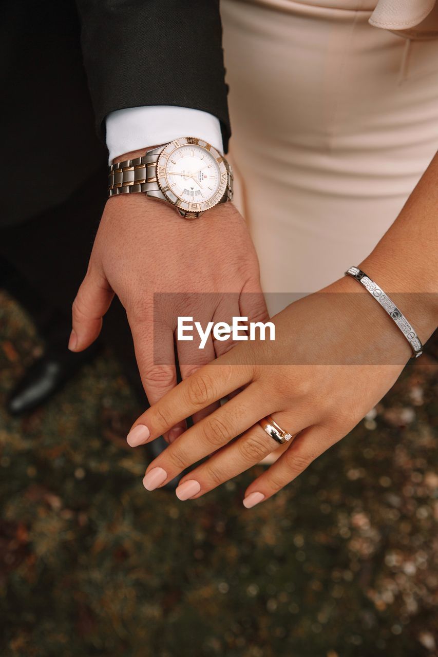 watch, ring, jewelry, hand, adult, fashion accessory, jewellery, women, wristwatch, finger, bracelet, holding hands, time, love, two people, celebration, wedding ring, event, togetherness, wedding, married, positive emotion, female, nail, arm, life events, men, bride, emotion, diamond, newlywed, lifestyles, close-up, fashion