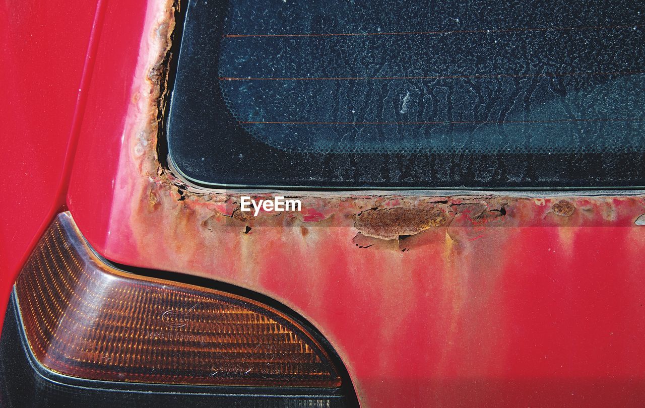 Close-up of red abandoned car