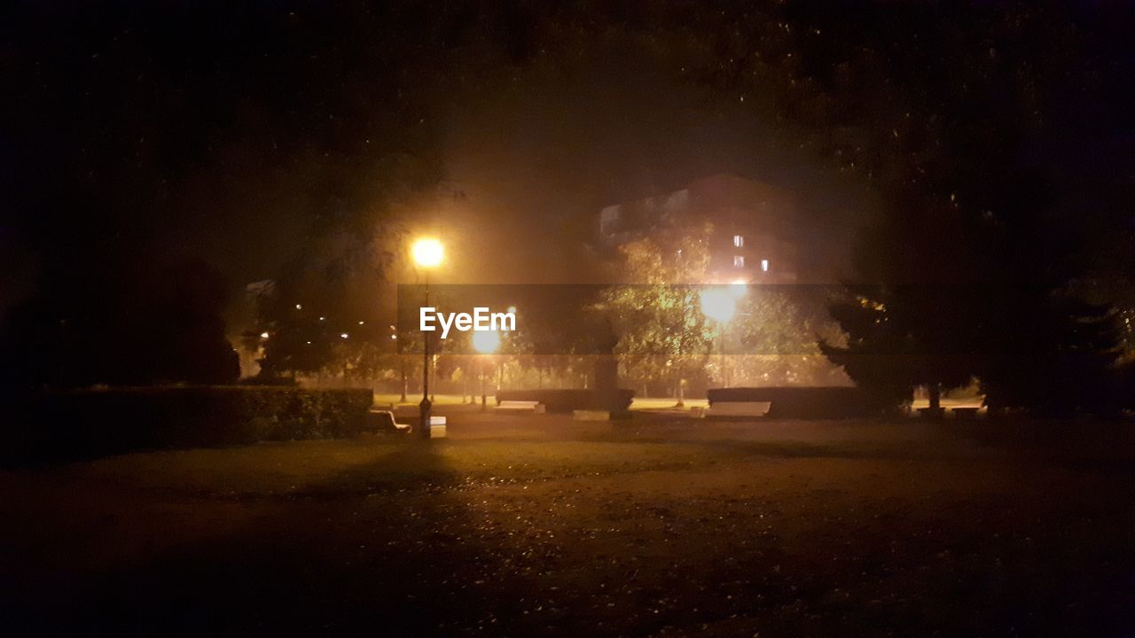 ILLUMINATED STREET LIGHTS ON FIELD AT NIGHT