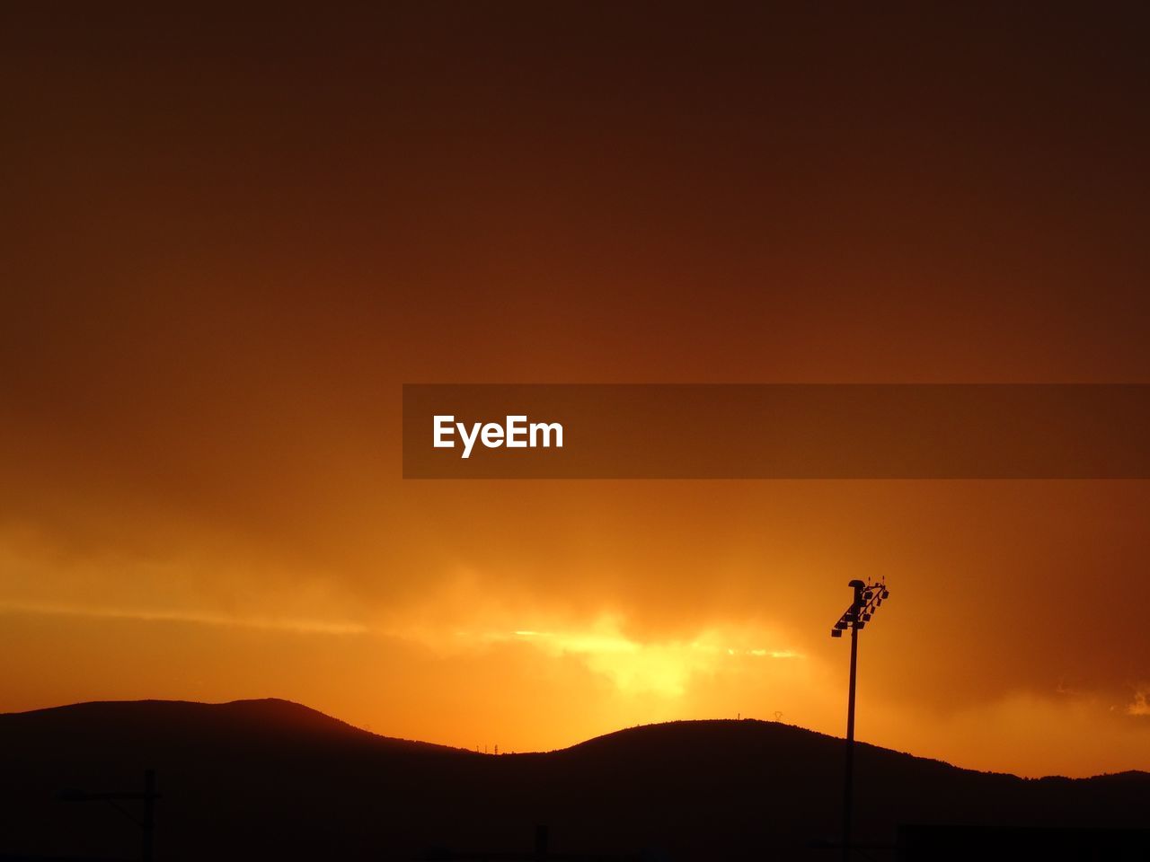 Low angle view of silhouette mountain against orange sky