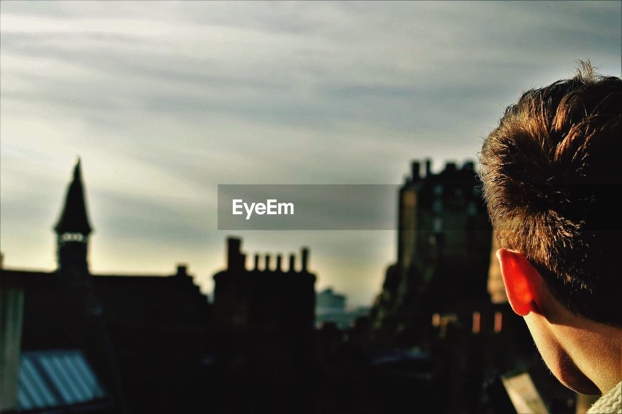Cropped image of man standing at edinburgh castle against sky