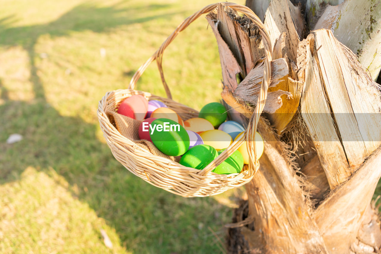 HIGH ANGLE VIEW OF MULTI COLORED EGGS IN WICKER BASKET