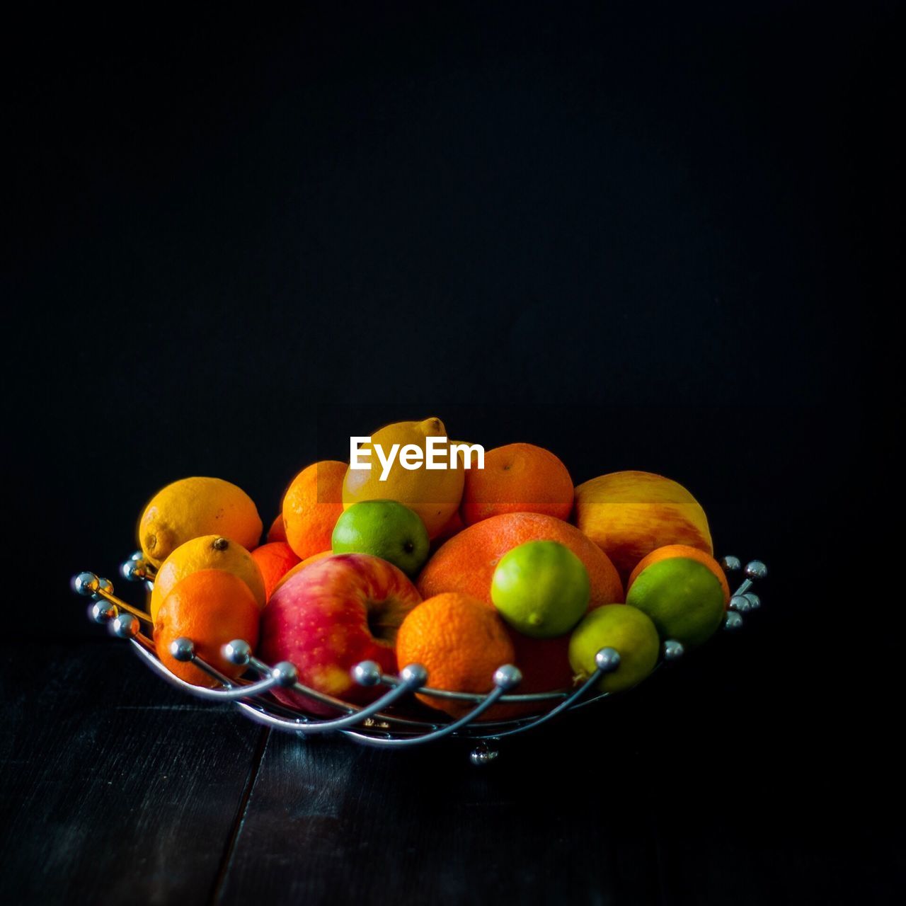 Close-up of fruits on table against black background