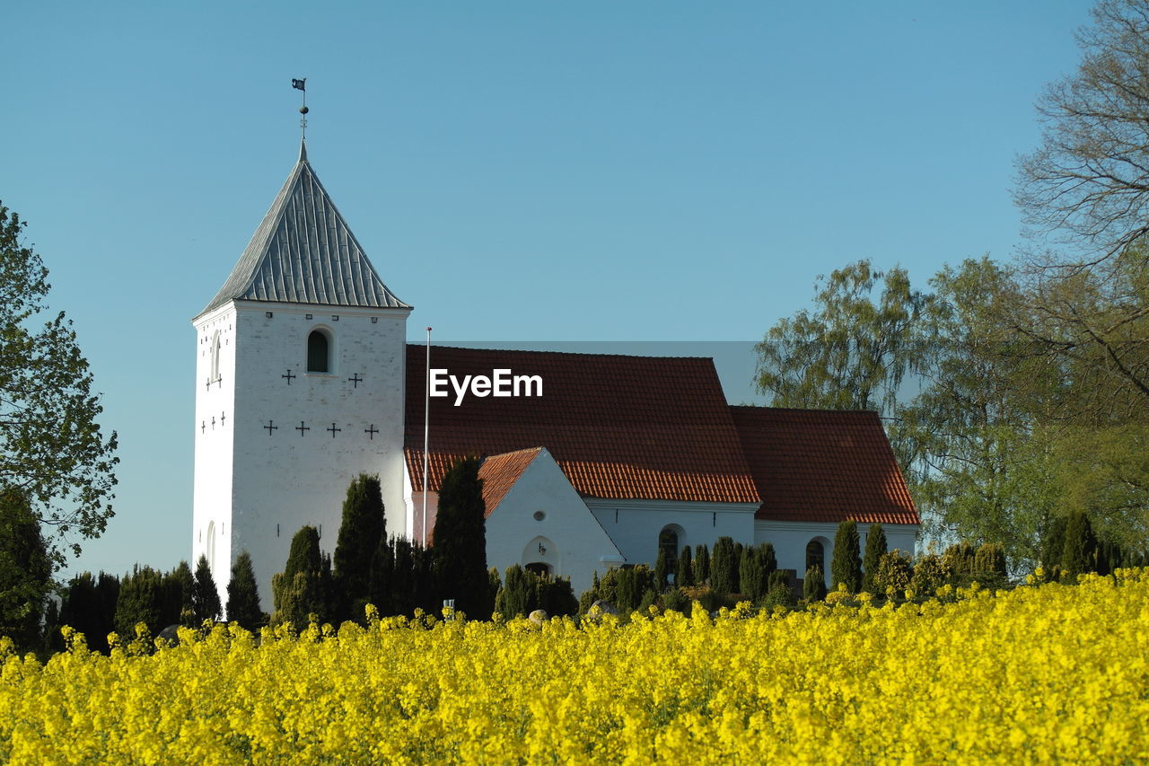 Church by field against clear sky