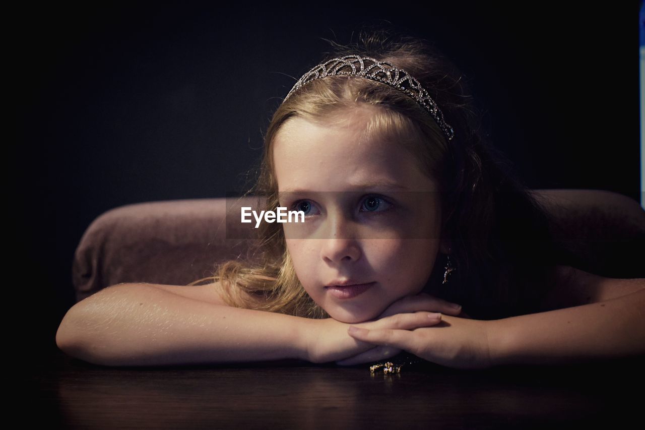 Close-up girl looking away while sitting at table