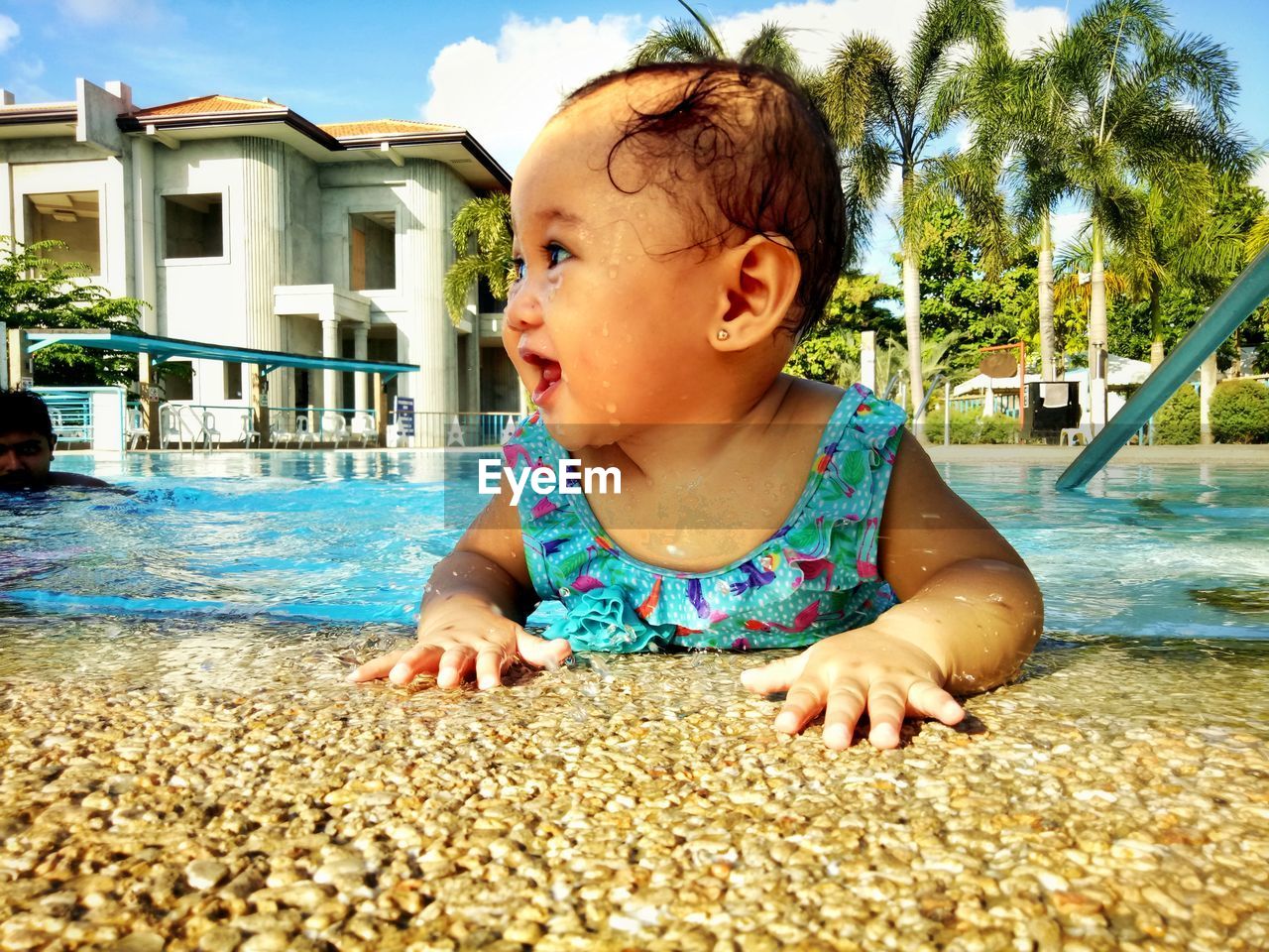 PORTRAIT OF CUTE BOY IN SWIMMING POOL AGAINST SKY