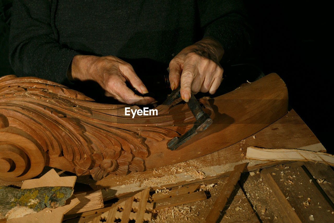 midsection of man working on wood
