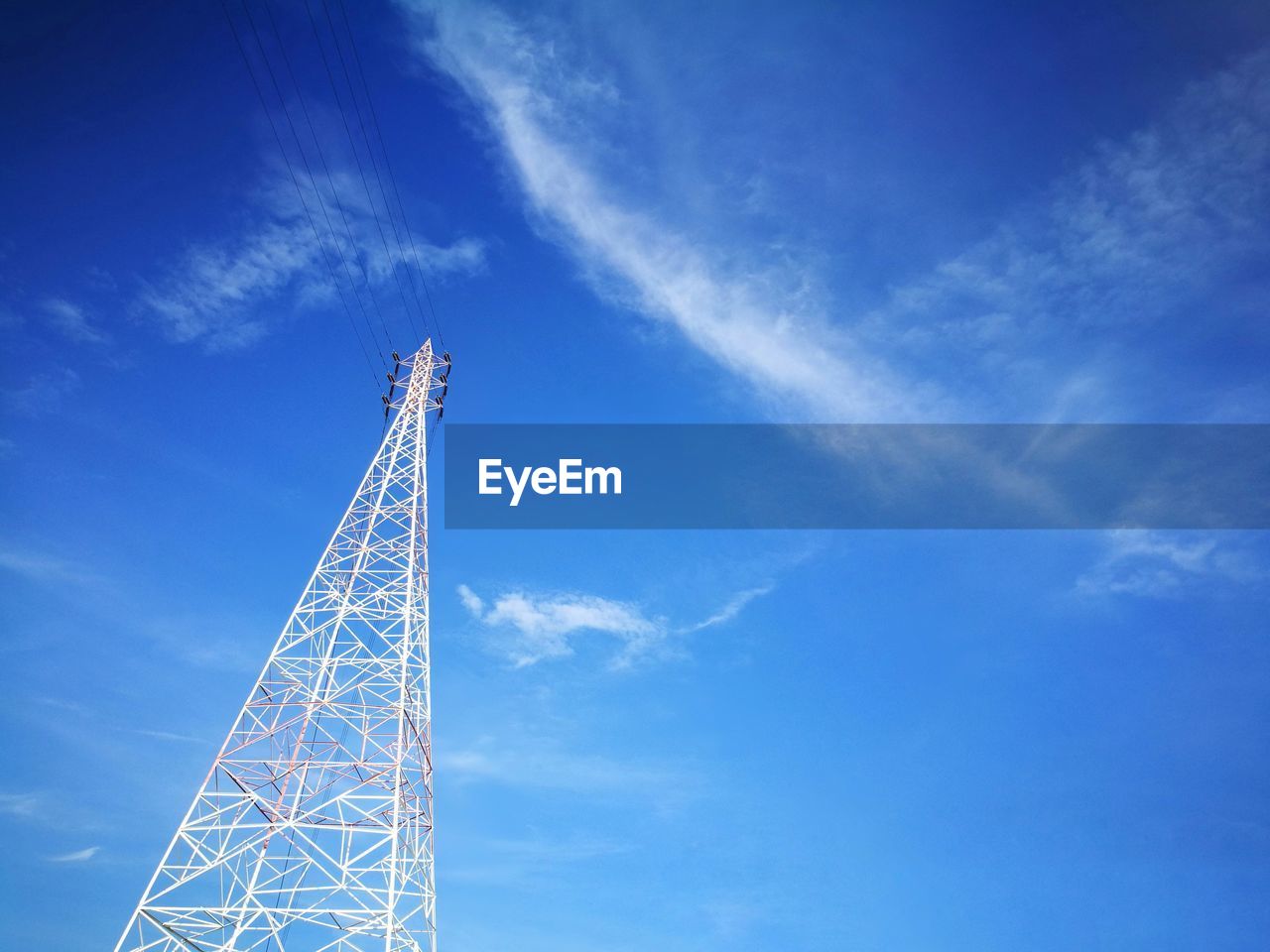 Low angle view of communications tower against blue sky