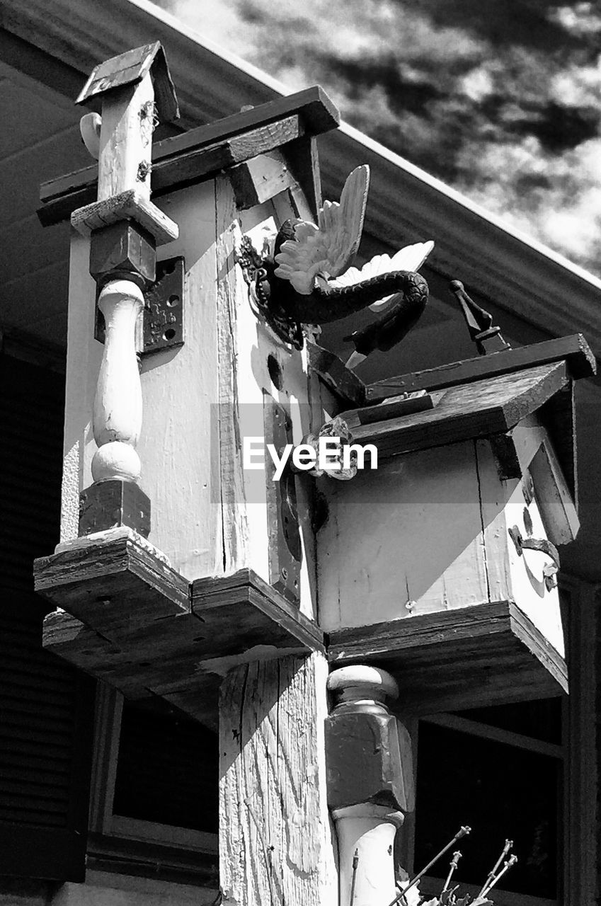 Low angle view of wooden birdhouse outside house