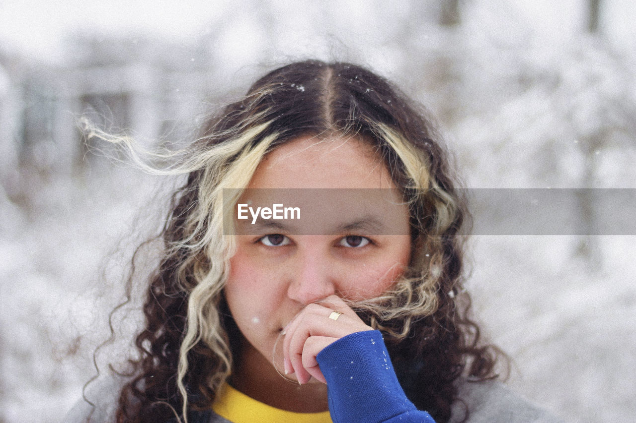 Portrait of young woman standing outdoors during winter