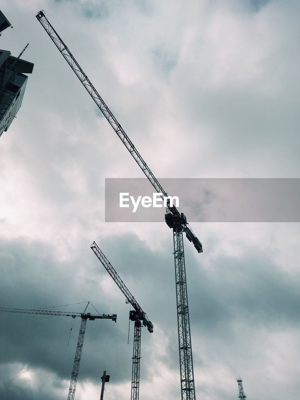 crane - construction machinery, cloud, machinery, construction industry, sky, industry, construction site, development, architecture, mast, electricity, overhead power line, construction machinery, blue, nature, business, built structure, line, low angle view, no people, business finance and industry, overcast, outdoors, construction equipment, wind, city, silhouette, tower, alloy, construction, cloudscape, steel, vehicle, unloading, metal