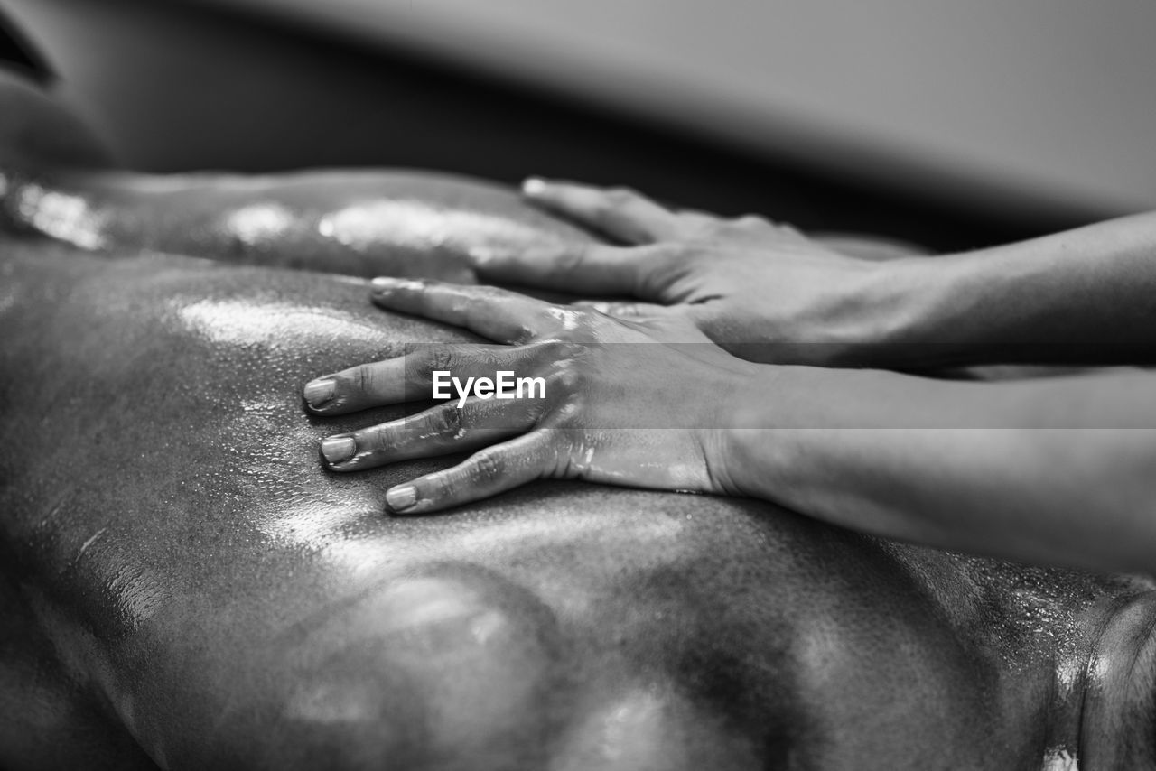 Woman massaging man lying on bed