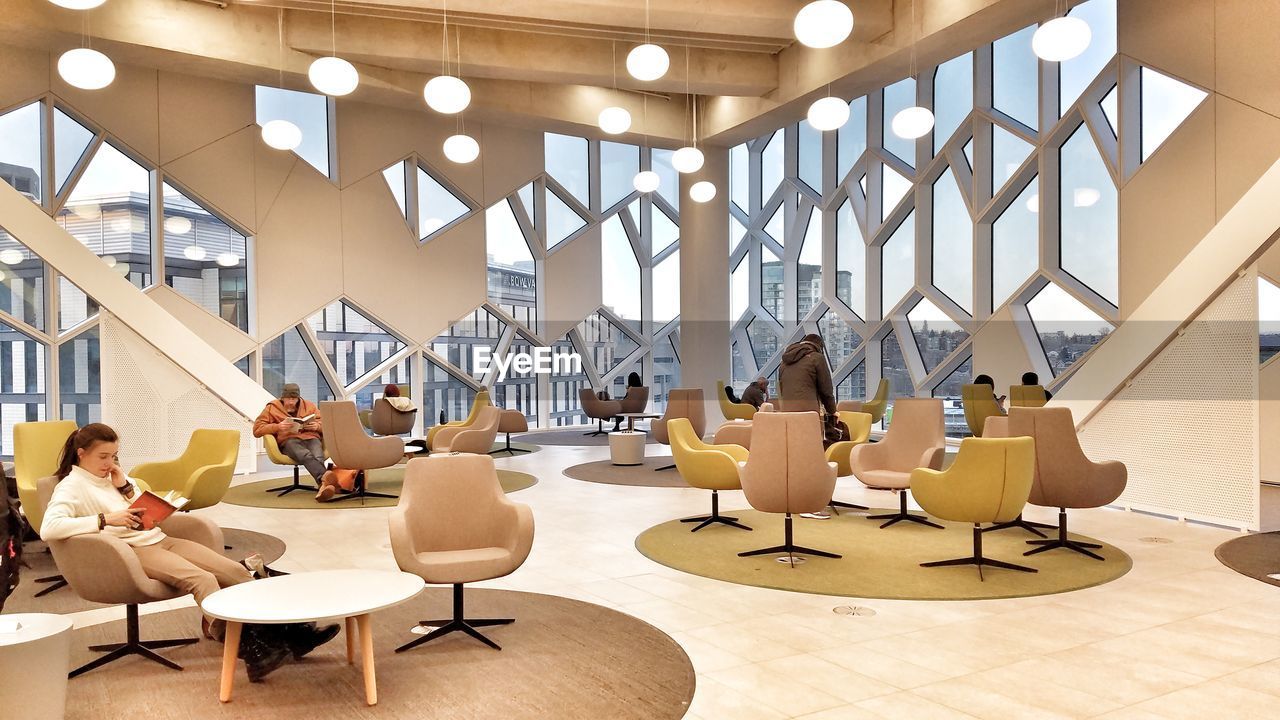 PEOPLE SITTING ON TABLE IN MODERN OFFICE