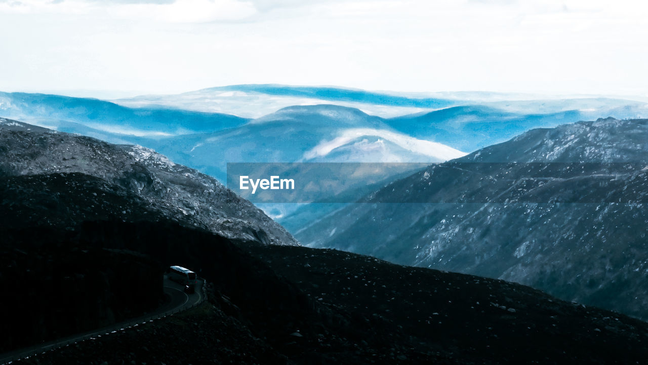 Scenic view of mountains against cloudy sky