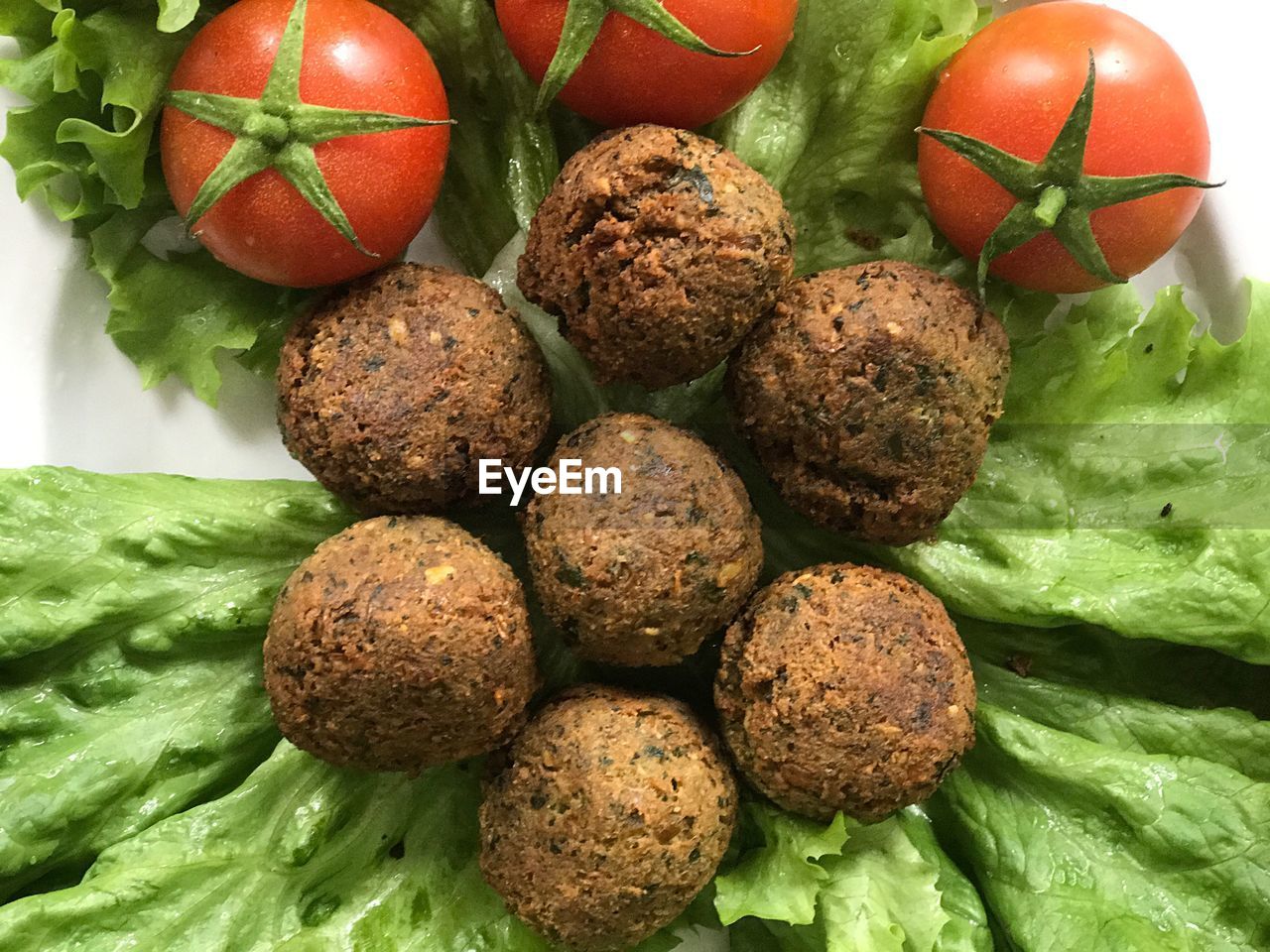 Close-up of falafels with cherry tomatoes and lettuce in plate