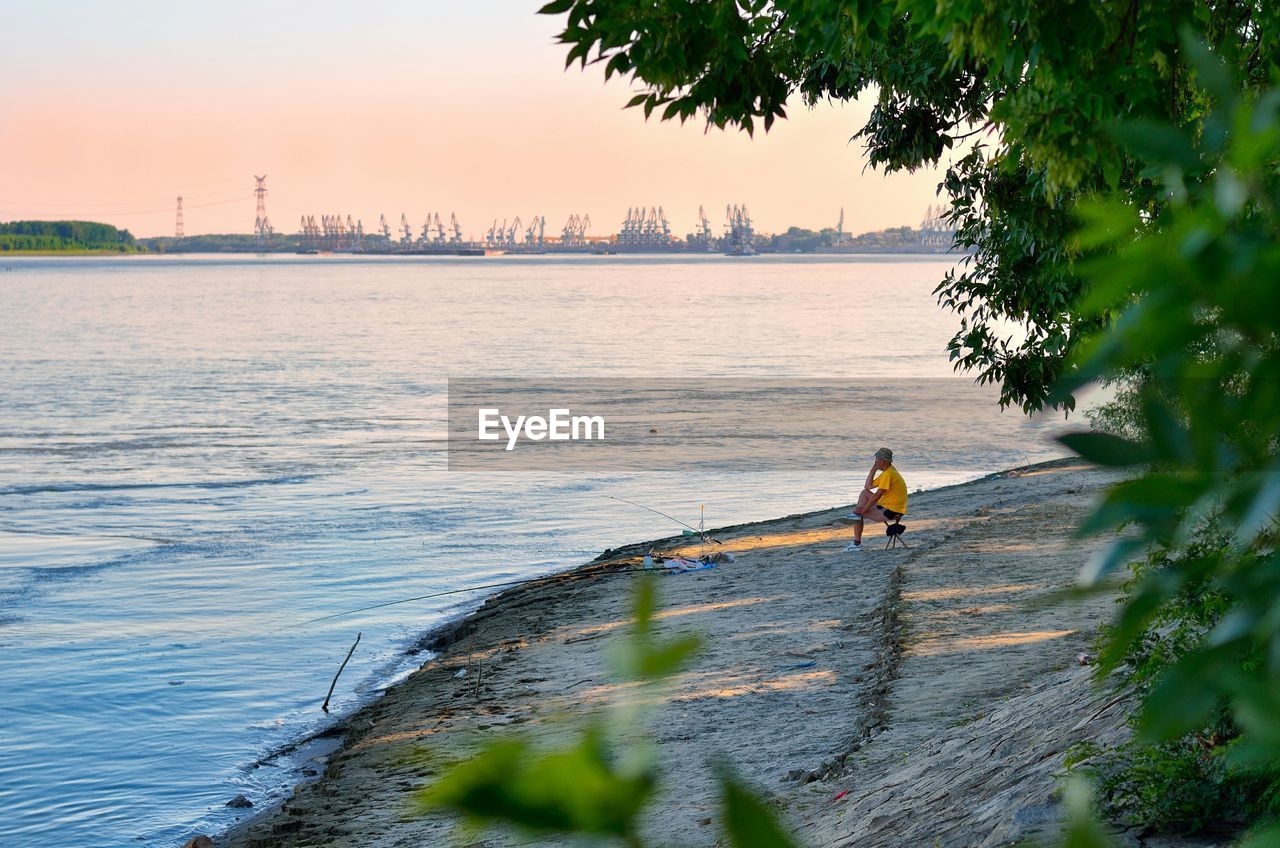 Side view of man overlooking calm sea