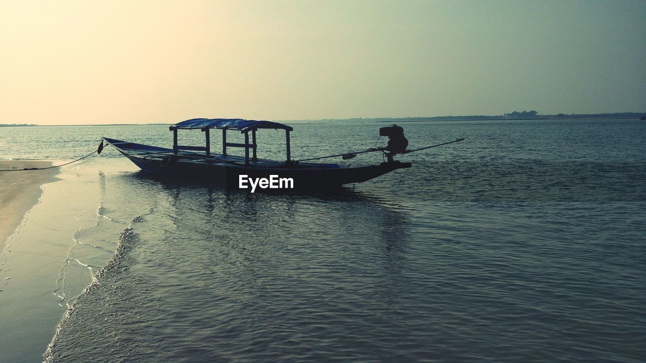 SILHOUETTE BOAT ON SEA AGAINST CLEAR SKY