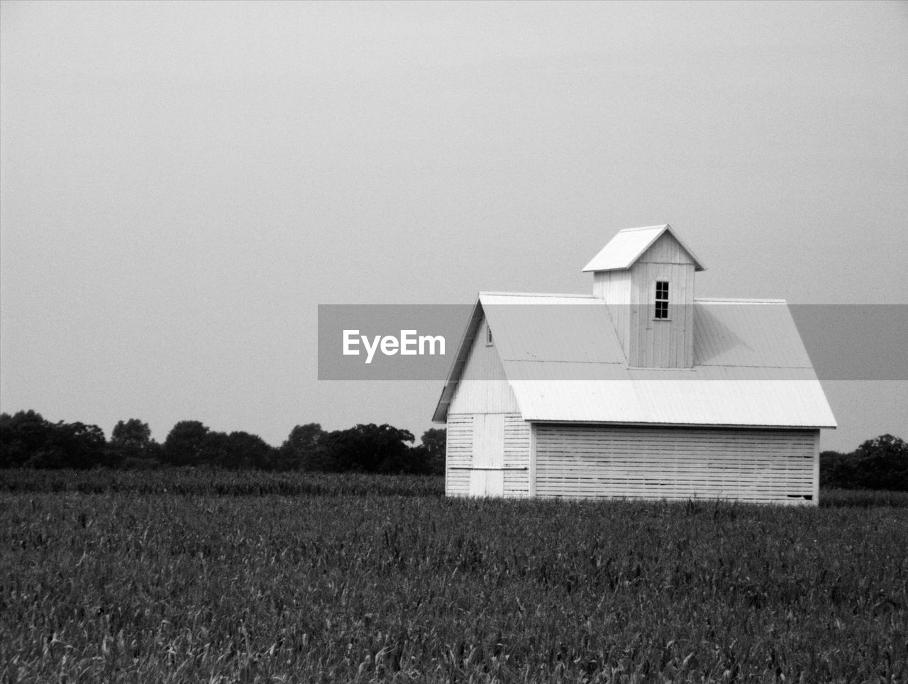 House on field against clear sky