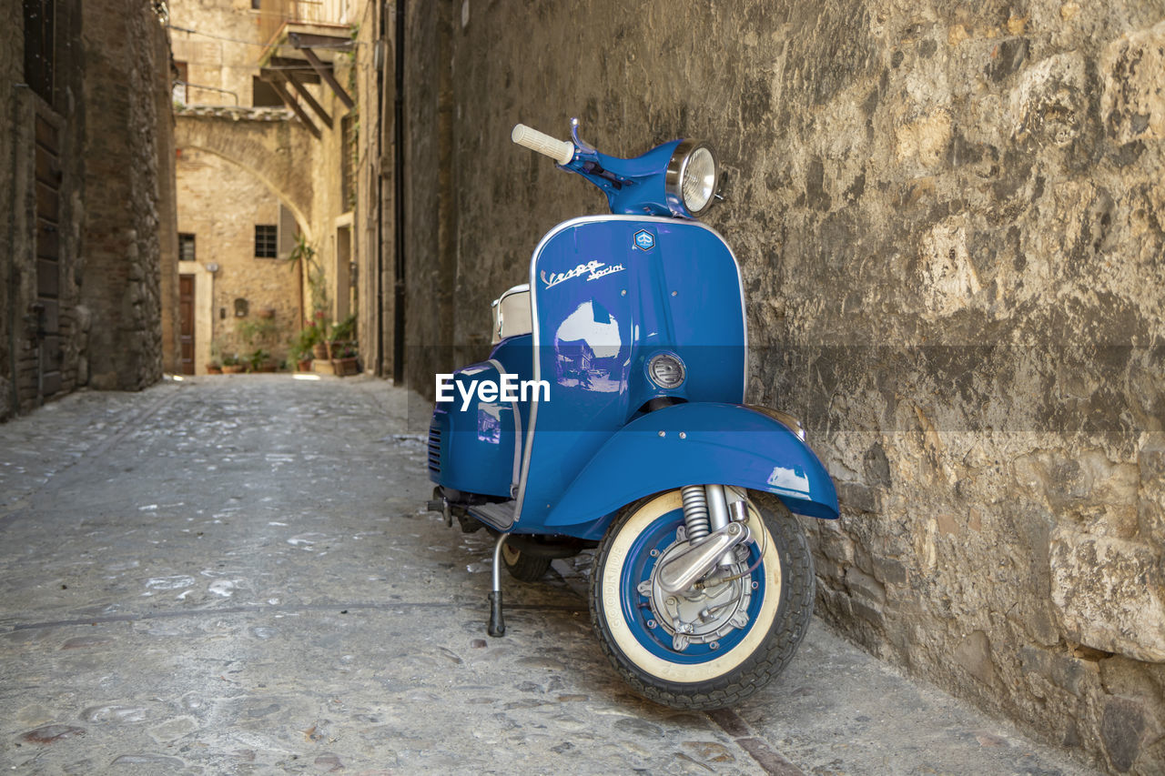 MOTOR SCOOTER ON STREET AGAINST BUILDINGS