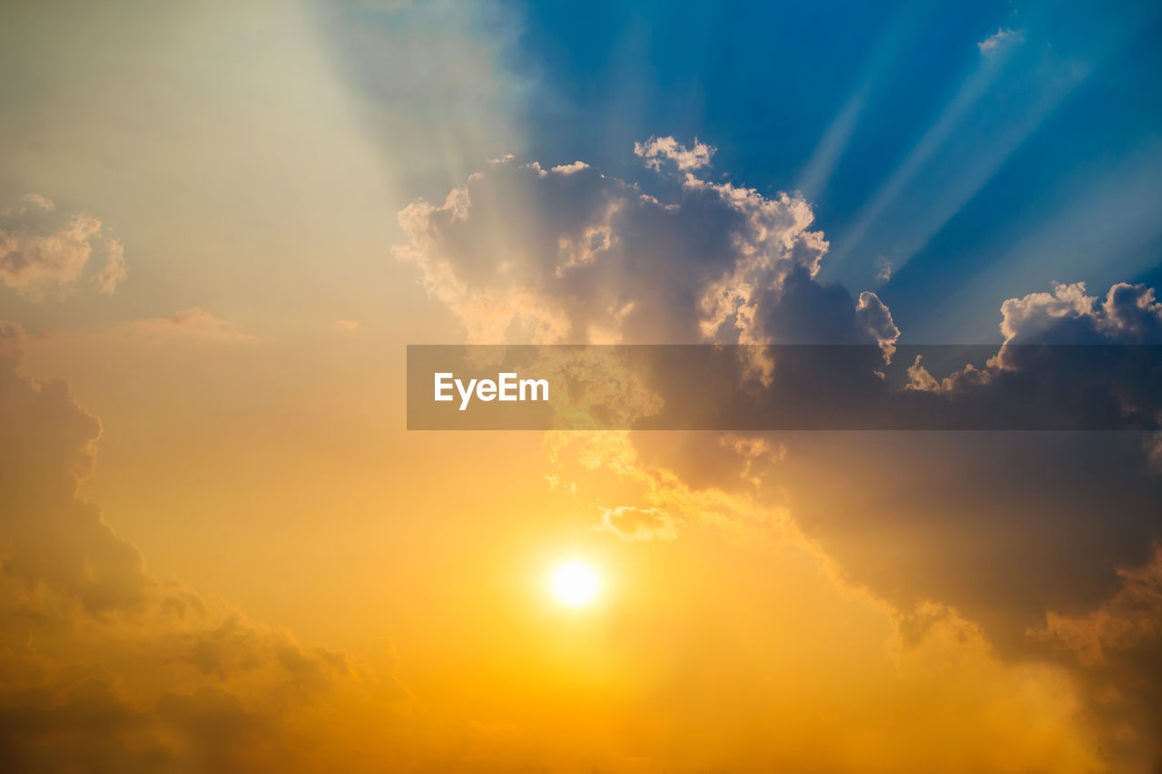 SUNLIGHT STREAMING THROUGH CLOUDS DURING SUNSET