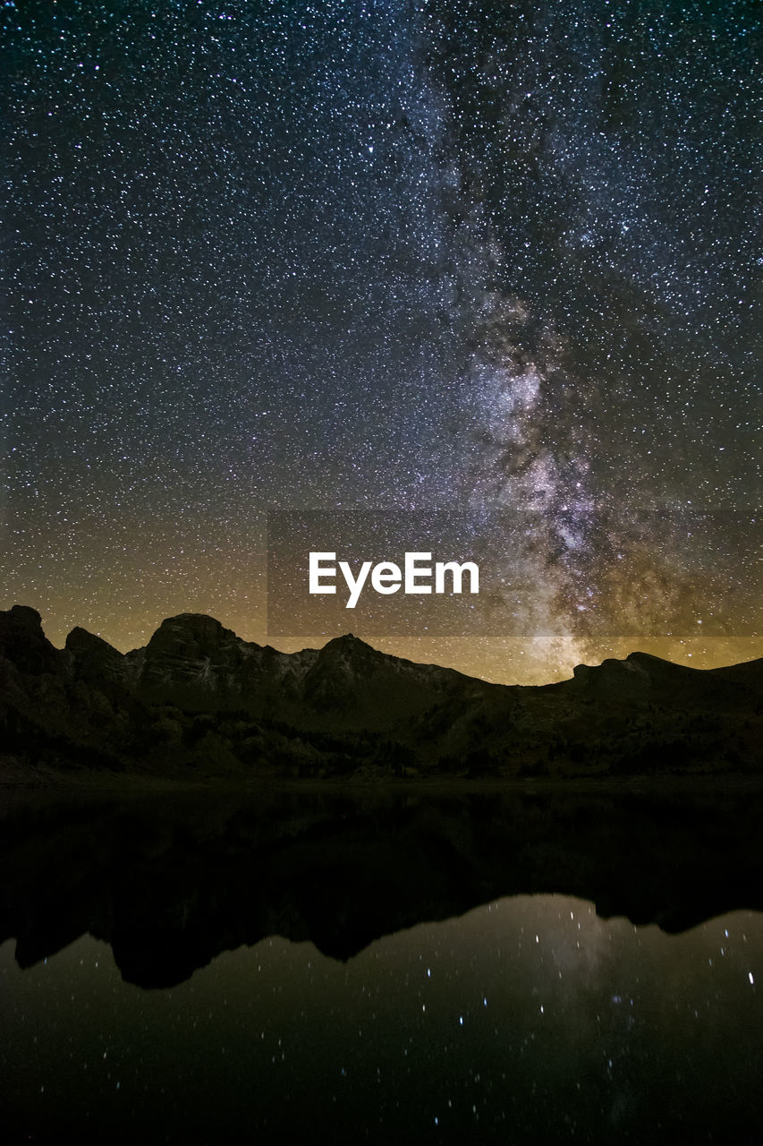 Scenic view of silhouette mountains against sky at night