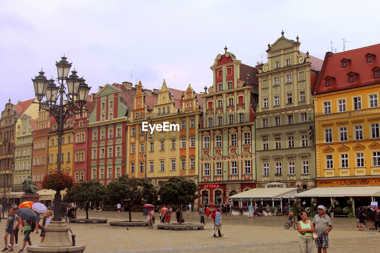 PEOPLE ON STREET AMIDST BUILDINGS IN TOWN