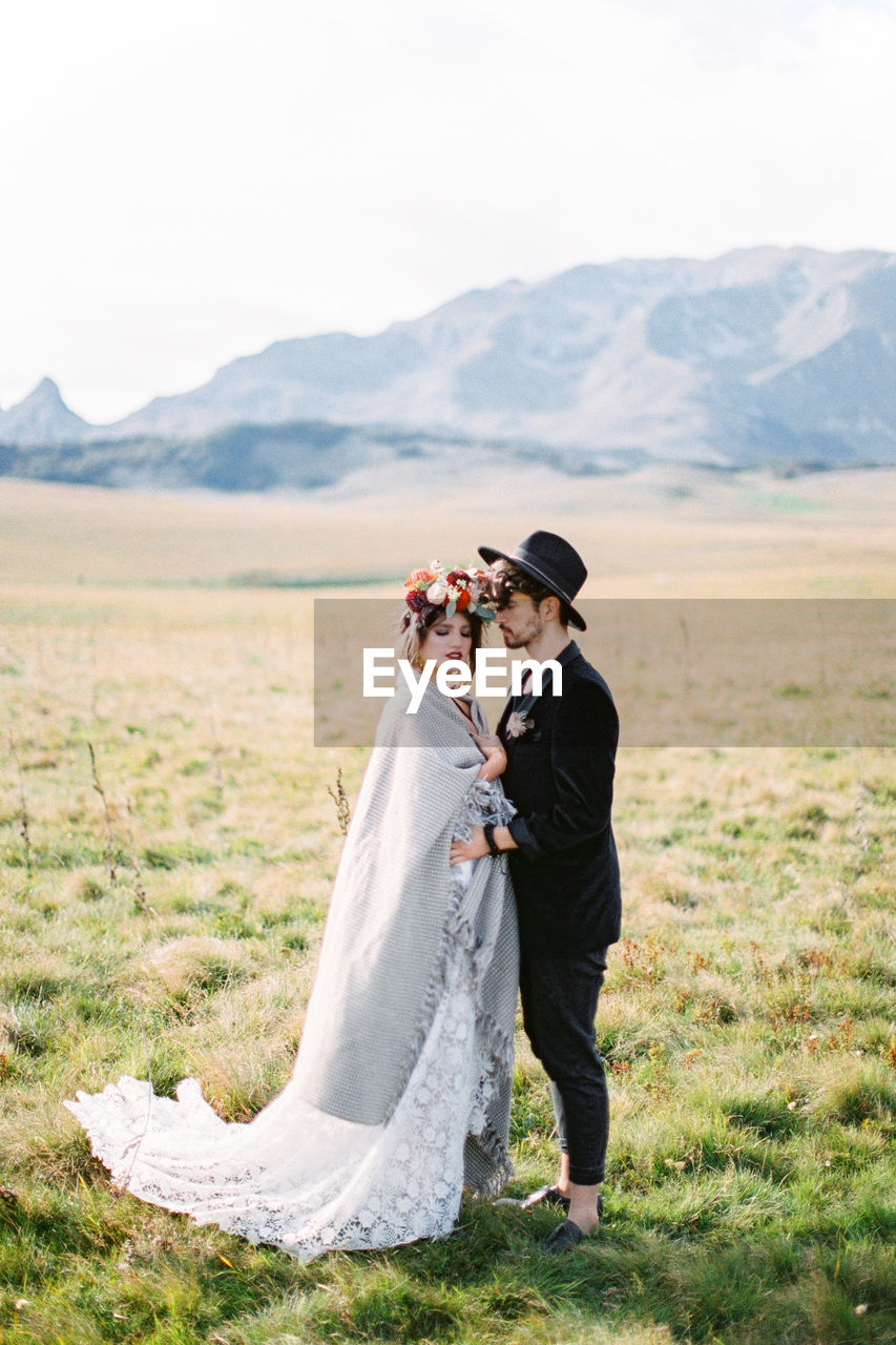 Man and woman standing on field