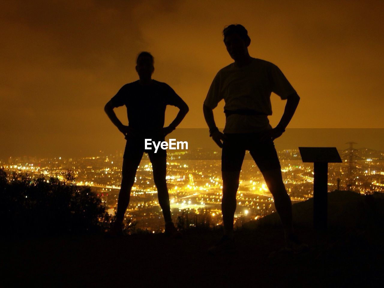 Silhouette of men standing on hill