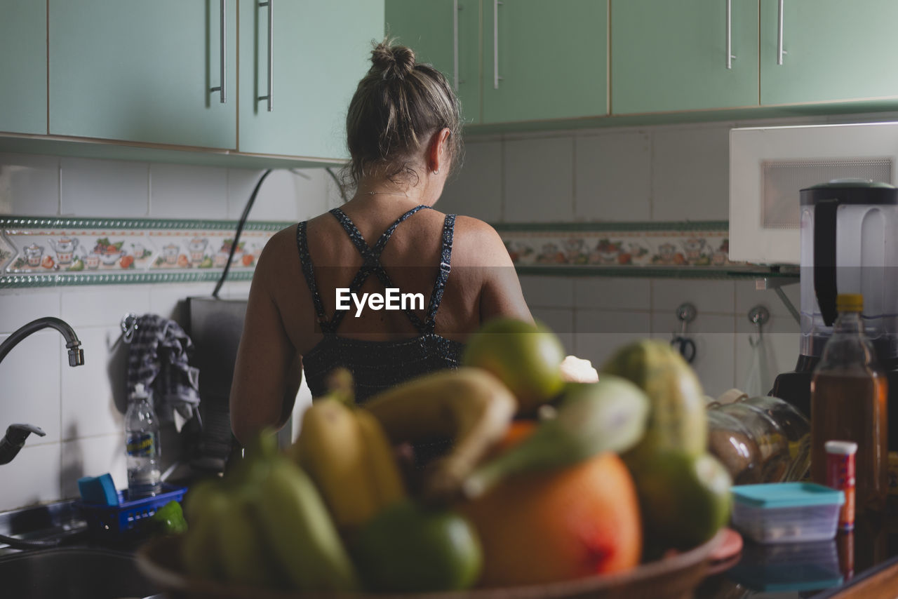 Caucasian woman with her back to her cooking in the kitchen. 