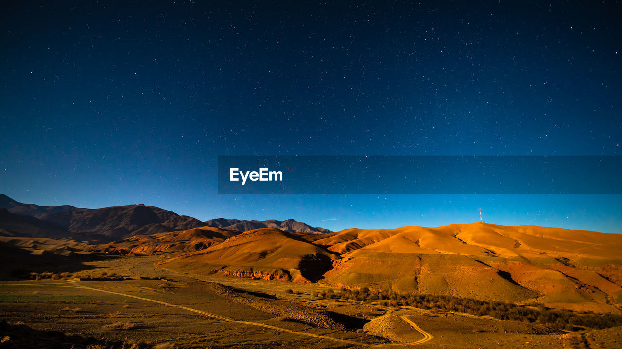 Scenic view of mountains against sky at night