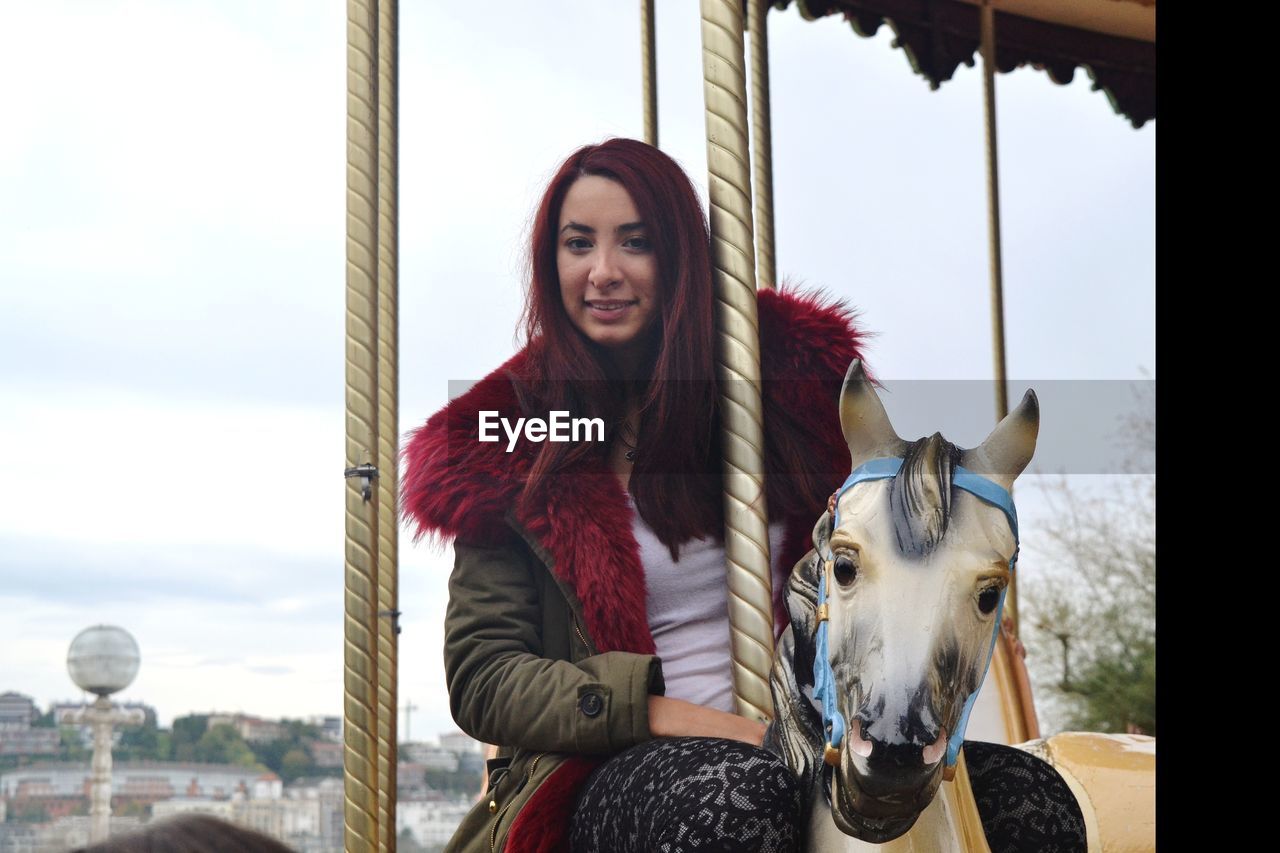 Portrait of young woman enjoying carousel