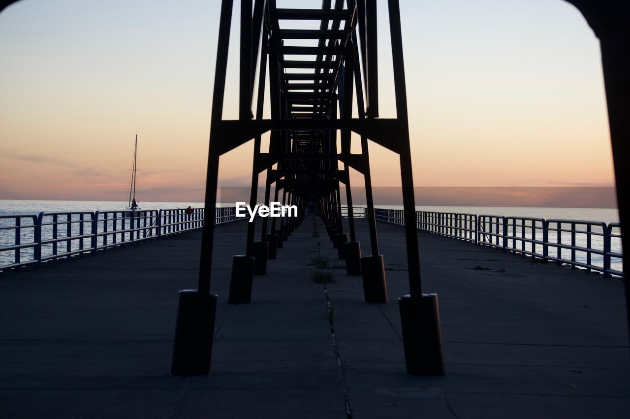 Silhouette pier on sea against sky at sunset